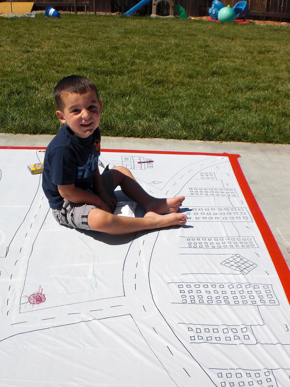 little kid smiling enjoying outdoor drawing activity for kids