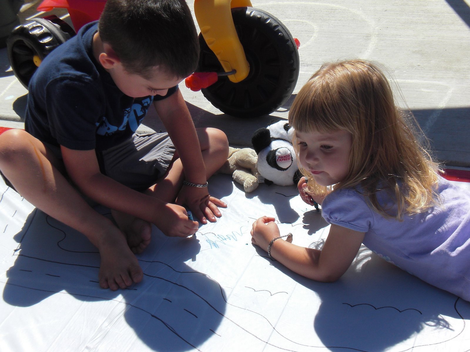 little kids playing outside together drawing