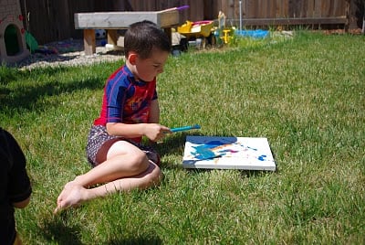 child outside making splatter art 