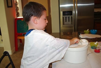 boy closing lid of salad spinner