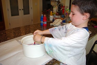 boy adding paint to plate