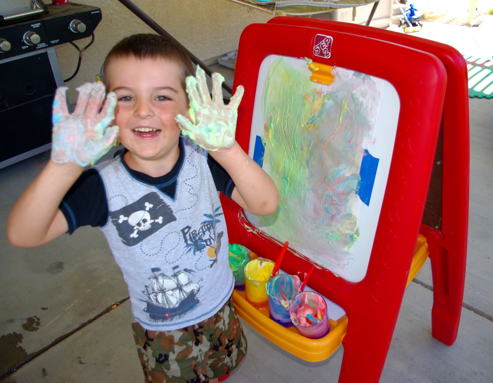 child with shaving cream paint hands next to easel 