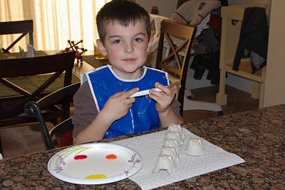 child painting egg carton